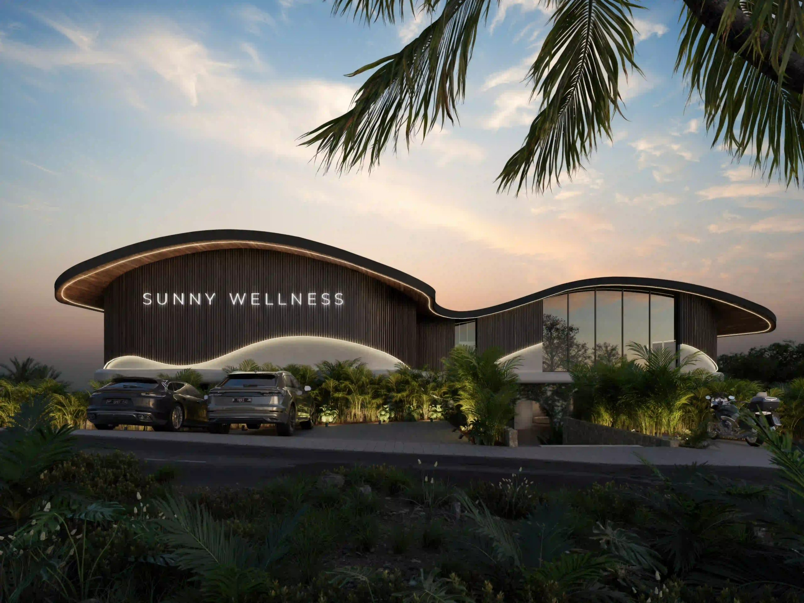 Modern exterior of the Sunny Wellness building at sunset, showcasing a wavy illuminated roof, vertical wood panels, and lush tropical landscaping.