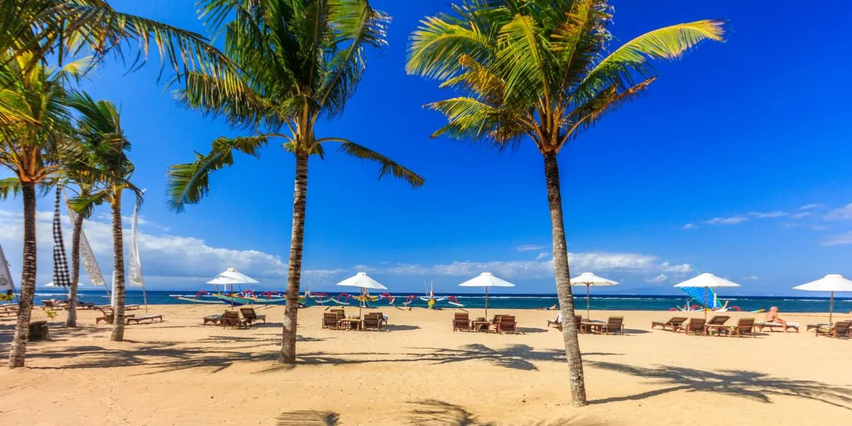 Colorful traditional outrigger boats on a white sand beach